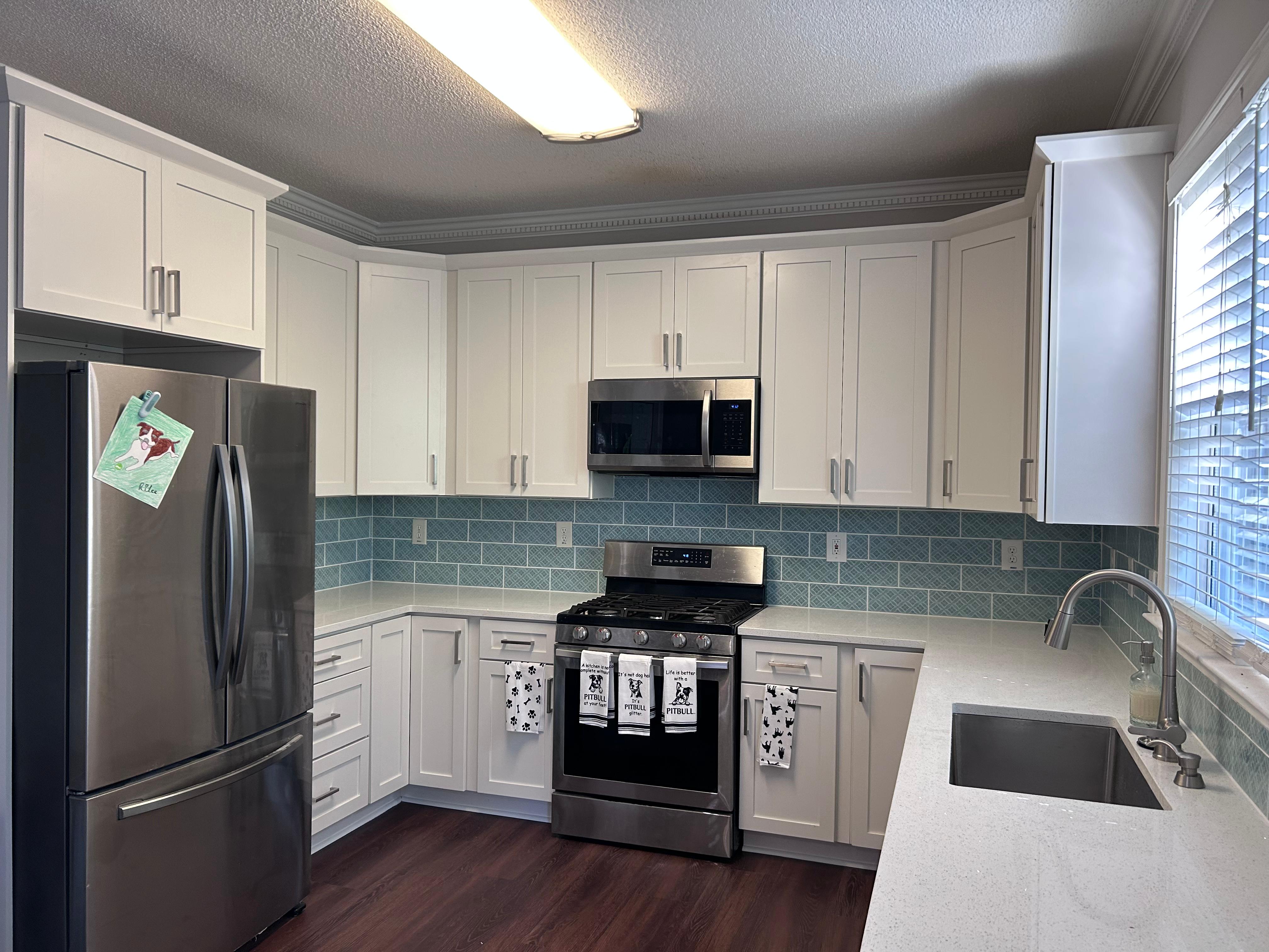 White quartz countertops with seafoam subway tile backsplash
