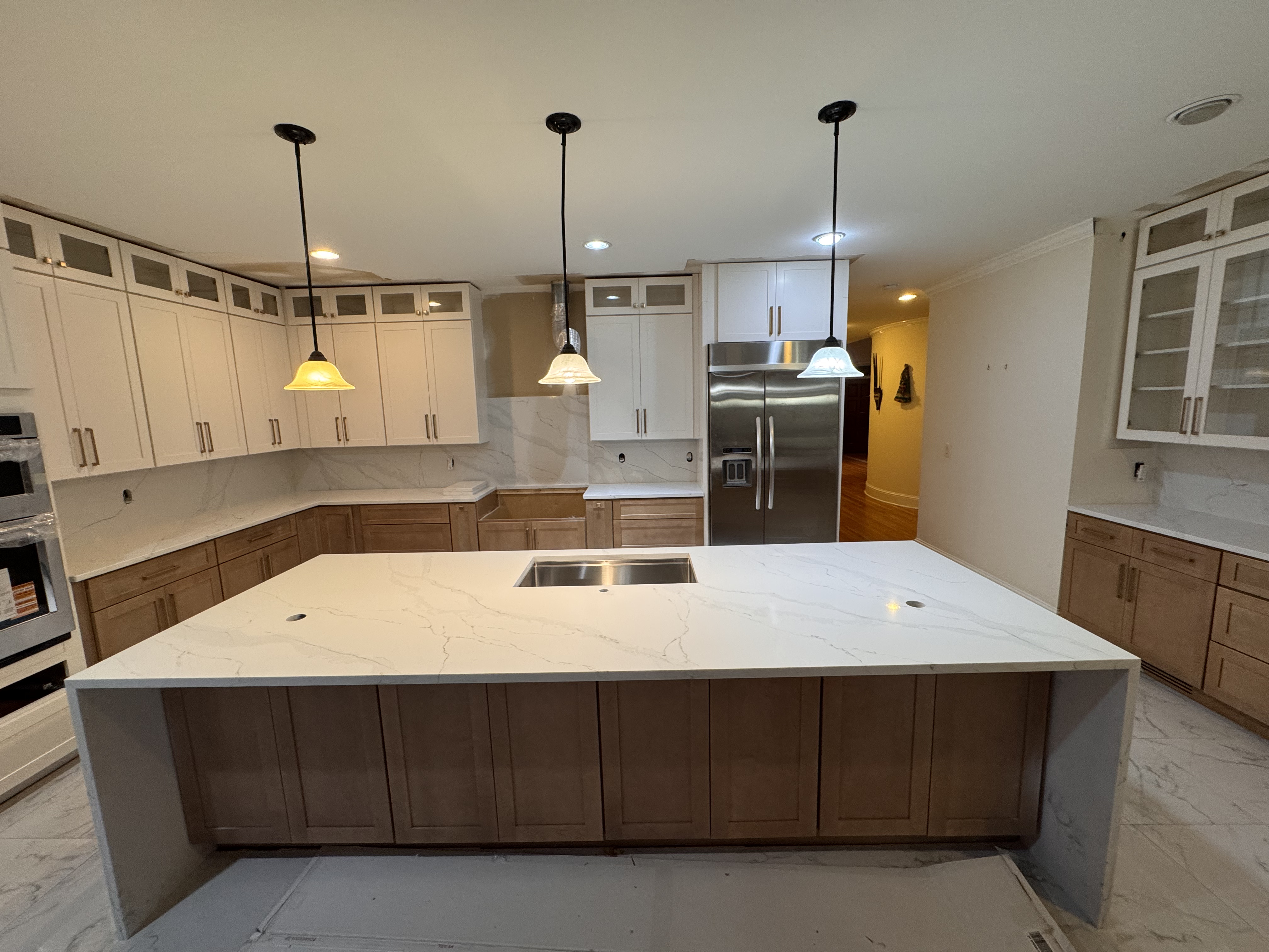 White quartz island with two-tone cabinetry